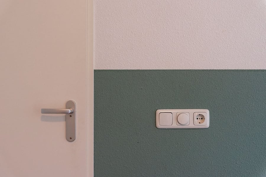 Interrupteur, variateur rotatif et prise encastrés sur un mur soigné