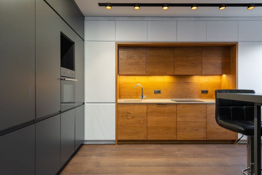 Cuisine contemporaine avec bandeau lumineux chaud sous les meubles hauts